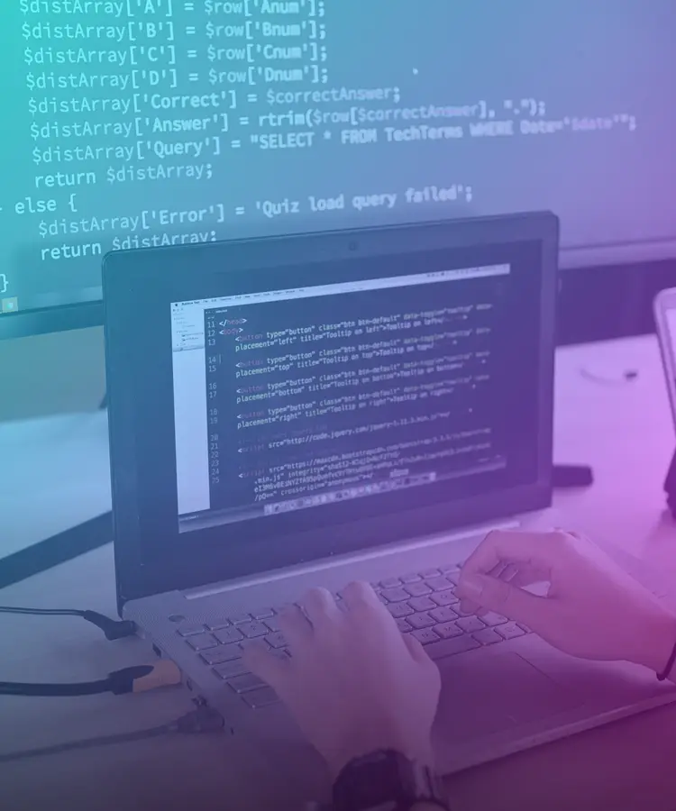 Persona programando en una laptop con código en pantalla