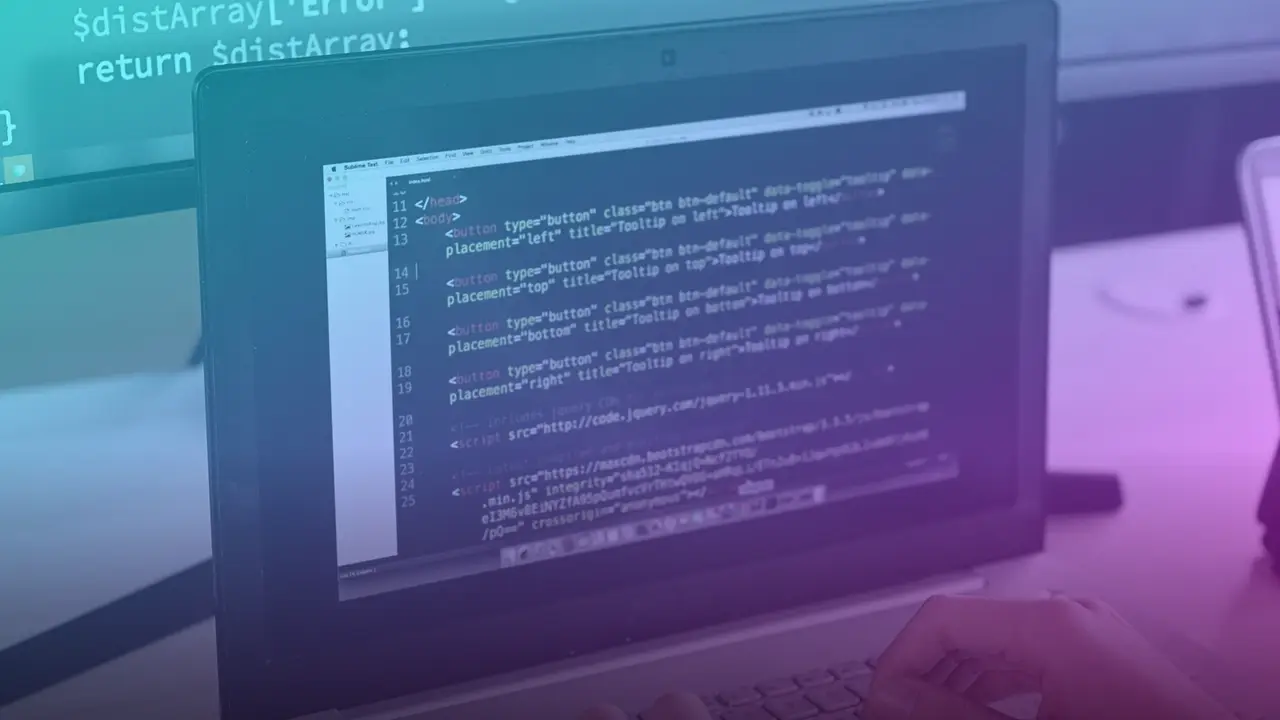 Persona programando con una laptop y un monitor externo con código en pantalla
