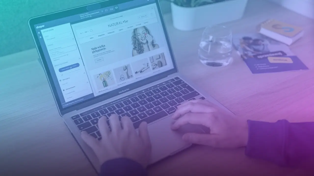 Manos escribiendo en una laptop que muestra una página web en edición