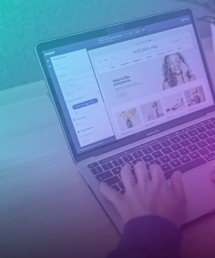 Manos escribiendo en una laptop que muestra una página web en edición