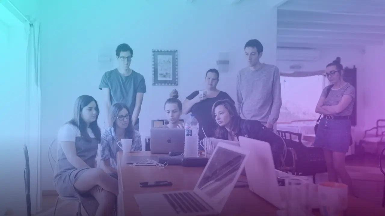 Grupo de jóvenes profesionales reunidos en torno a una mesa de trabajo