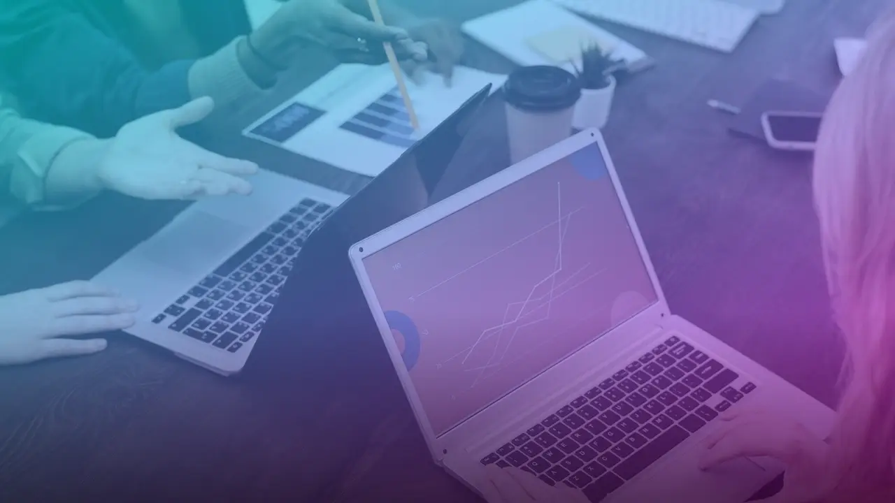 Equipo revisando gráficos de resultados en una laptop sobre una mesa de trabajo